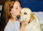 A happy yellow Labrador giving Simona an affectionate kiss on the cheek