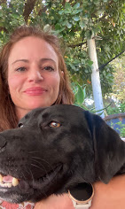 Simona with a black Labrador in the lush South Paws garden after a walk